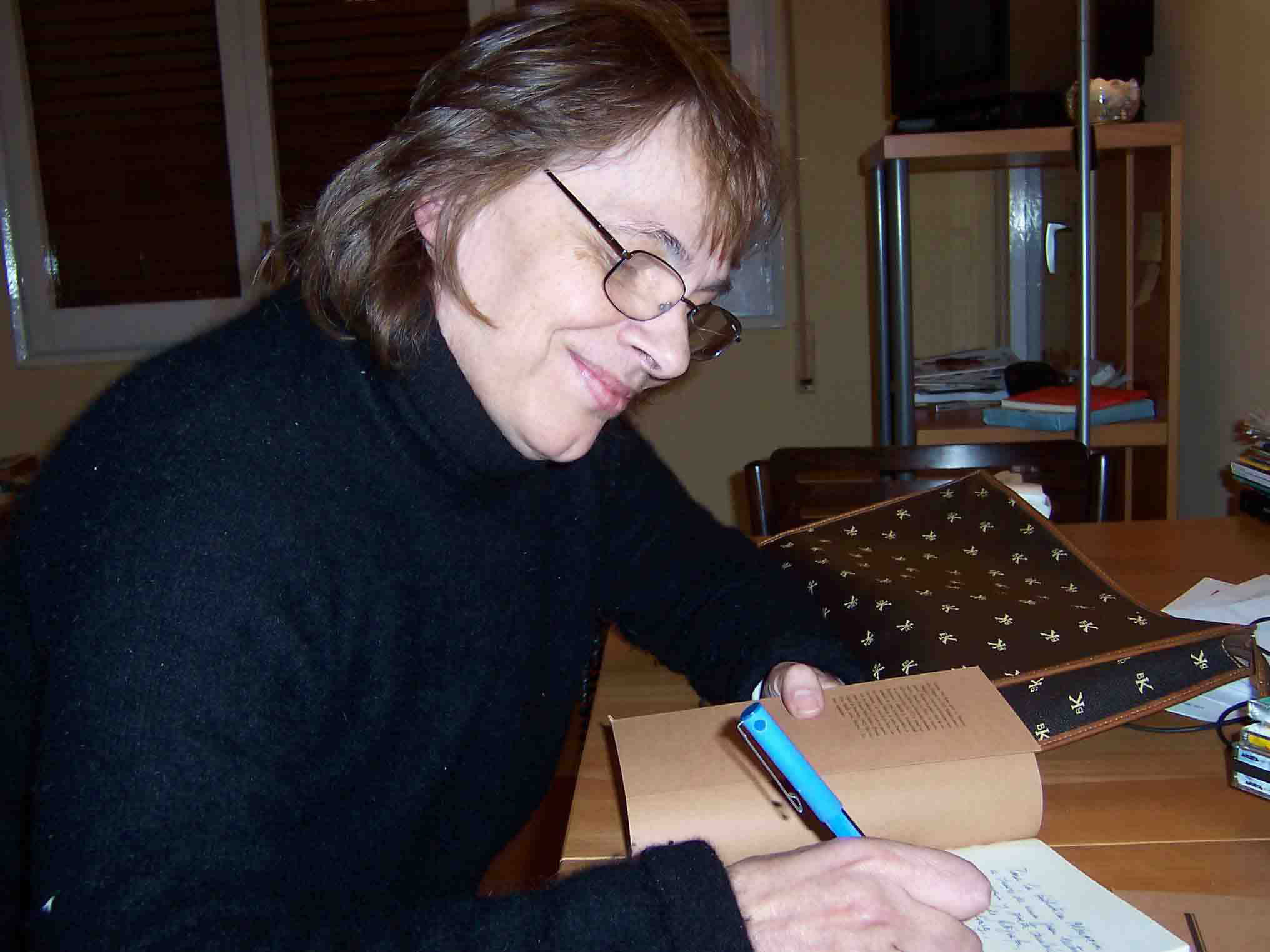La escritora uruguaya Cristina Peri Rossi firmando una dedicatoria en un libro.