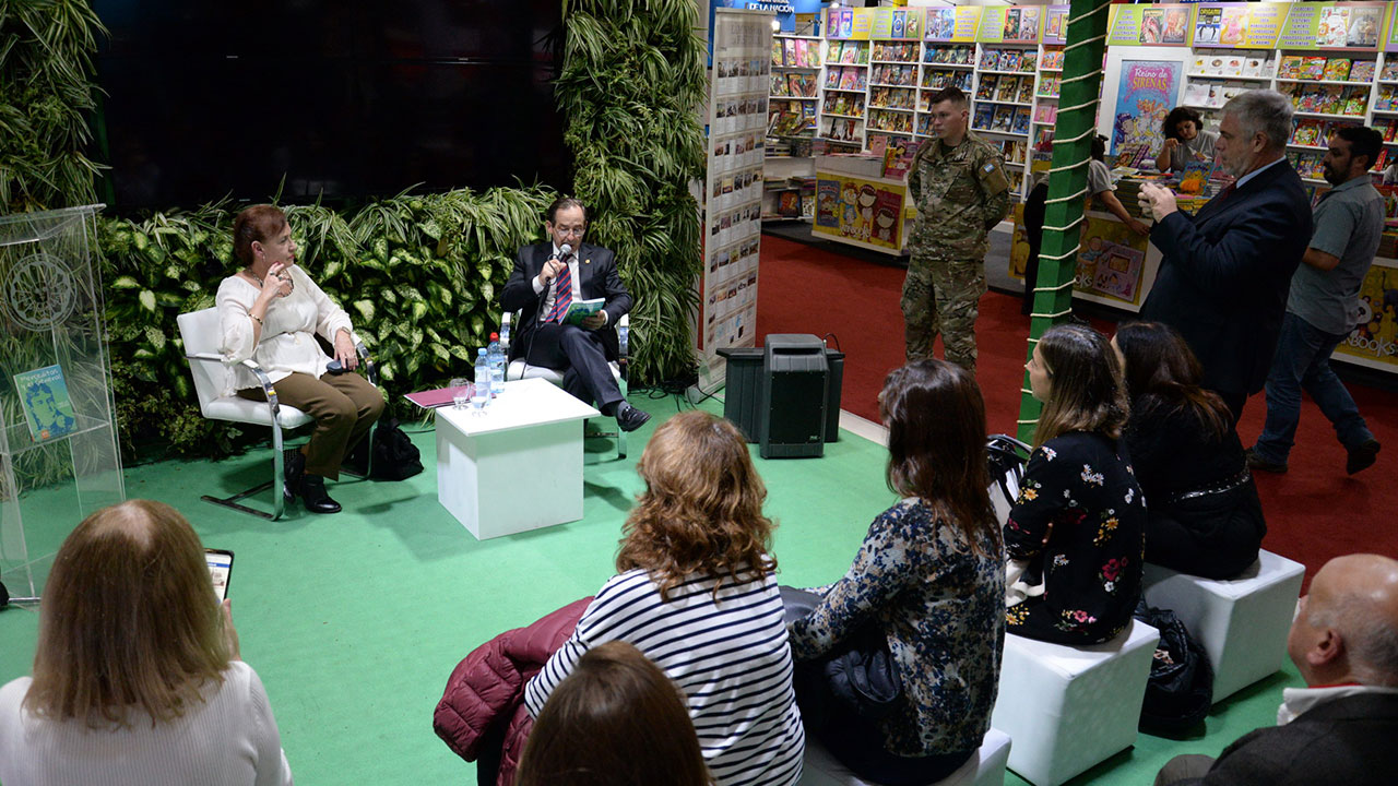 La escritora Marta Garber, acompañado por el coronel Alejandro Urricariet, exponiendo su libro frente al público