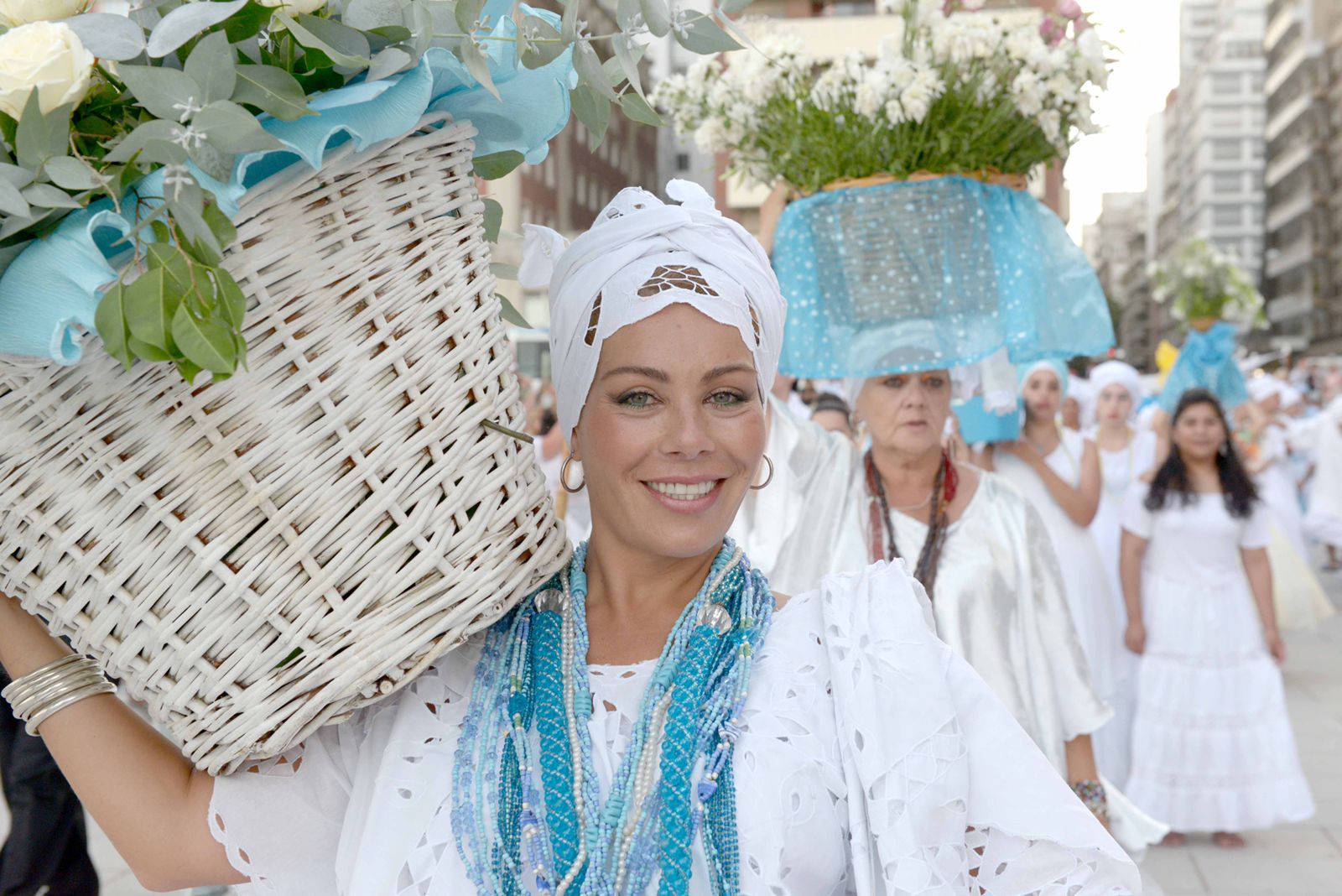  Mujer con la vestimenta tradicional carga su ofrenda de flores. 