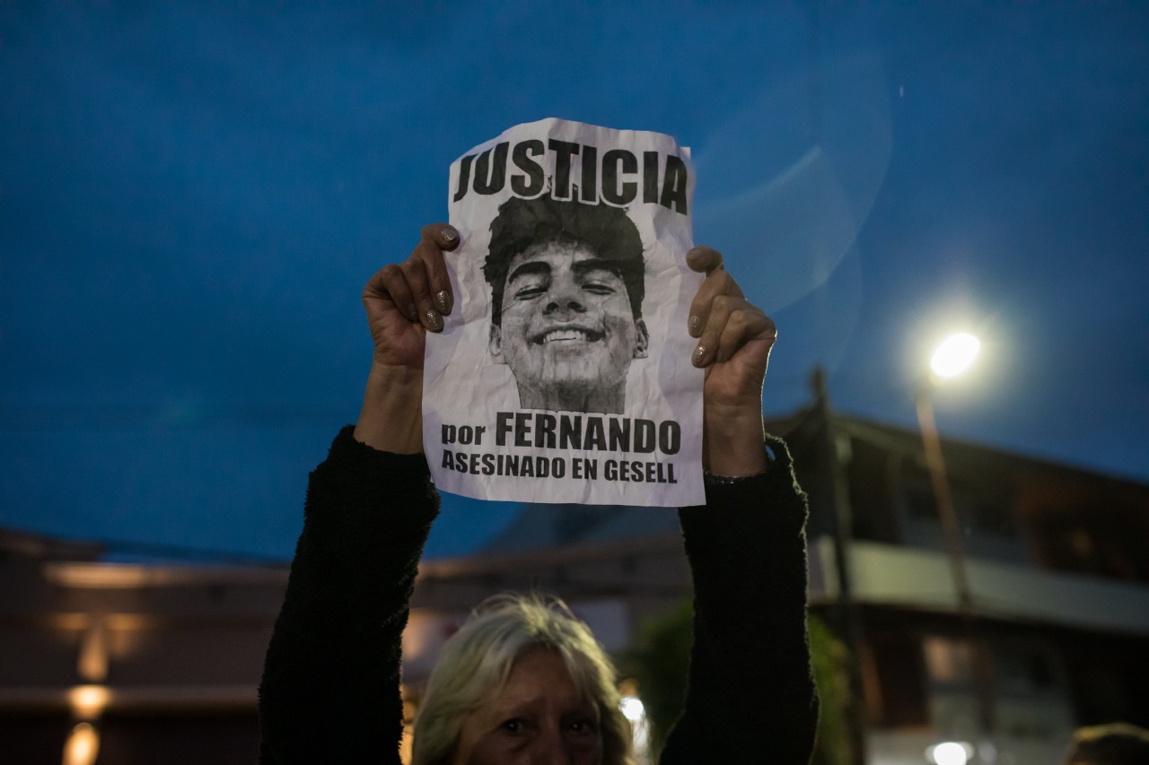 Mujer levanta con ambas manos el cartel de Justicia por Fernando