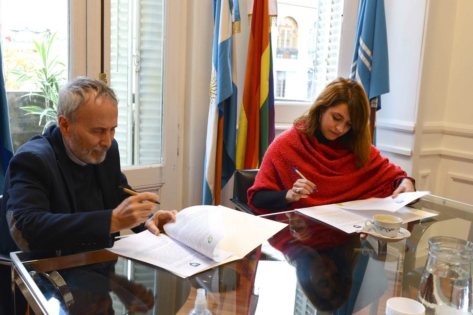 Rodolfo y Victoria firman los convenios en el salon de reuniones de INADI central