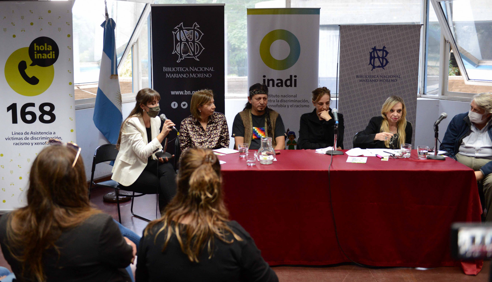 Panel expositor Panel expositor con banners del INADI de fondo
