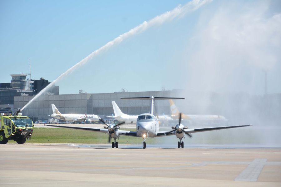 El segundo Bechcraft b-200 de la Fuerza Aérea cruza el arco de agua que simboliza su bautismo