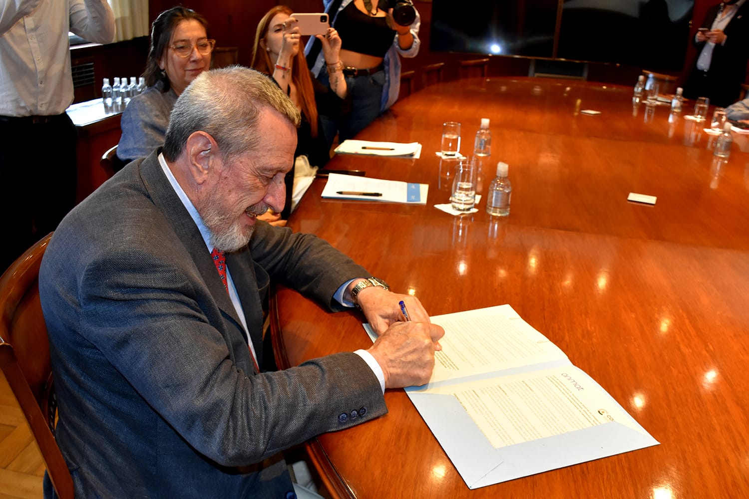 Manuel Limeres, administrador nacional, firma la Carta de Intención en la mesa de reunión