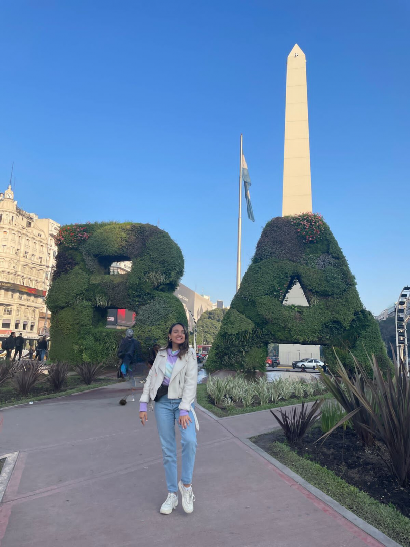 La becaria frente al Obelisco y al Jardín Vertical BA, Ciudad de Buenos Aires.