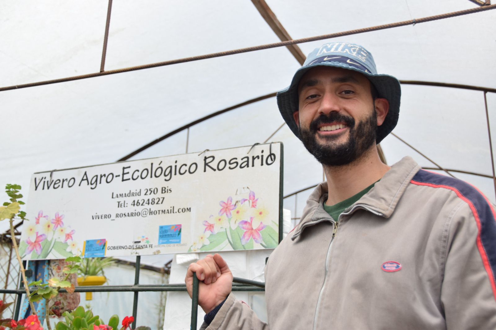 Imágen de un hombre dentro del vivero agroecológico de Rosario, con el cartel de dicho vivero detrás de él,