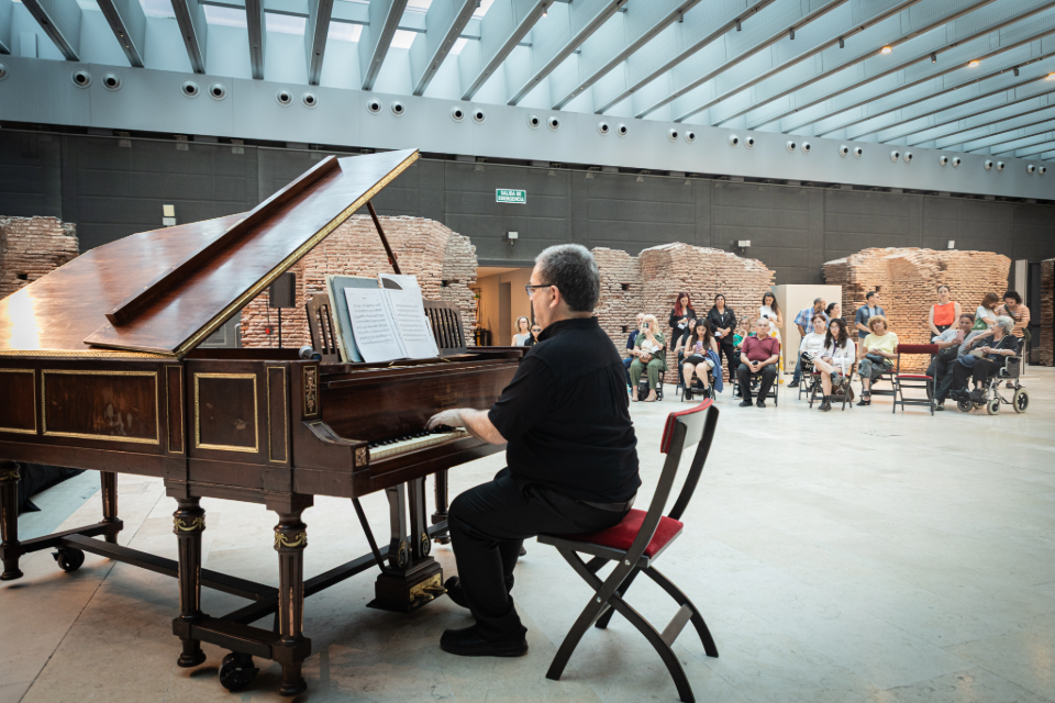 Fotografía de Walter Cáceres tocando el piano en el Museo Casa Rosada