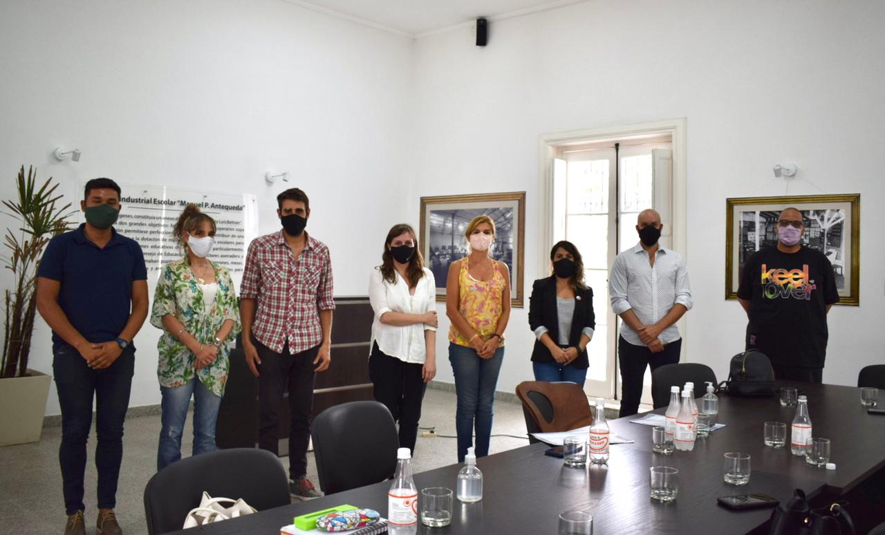 Grupo de personas posan detrás de una mesa.
