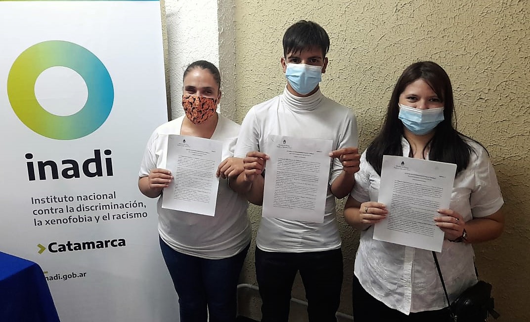 Doria, Díaz y Aybar posan con sus contratos en mano junto a un banner del organism