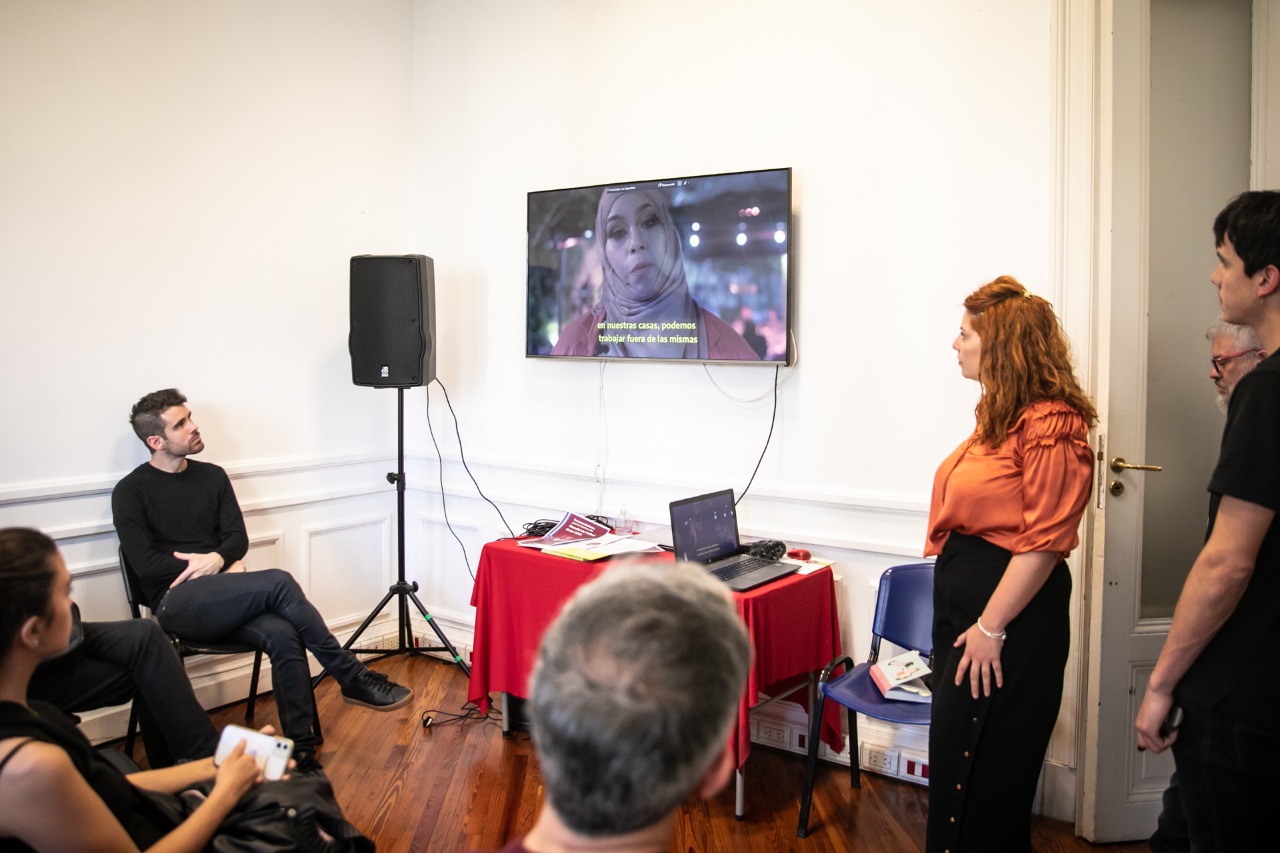 Melody Amal Khalil Kabalan de pie exponiendo un video a la espera de las preguntas por parte del público