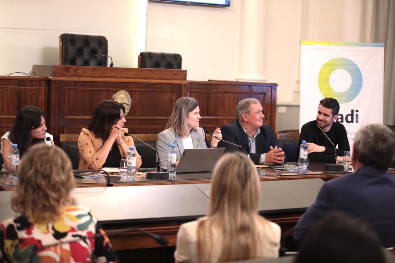 Les panelistas sentados de frente al público durante la presentación.