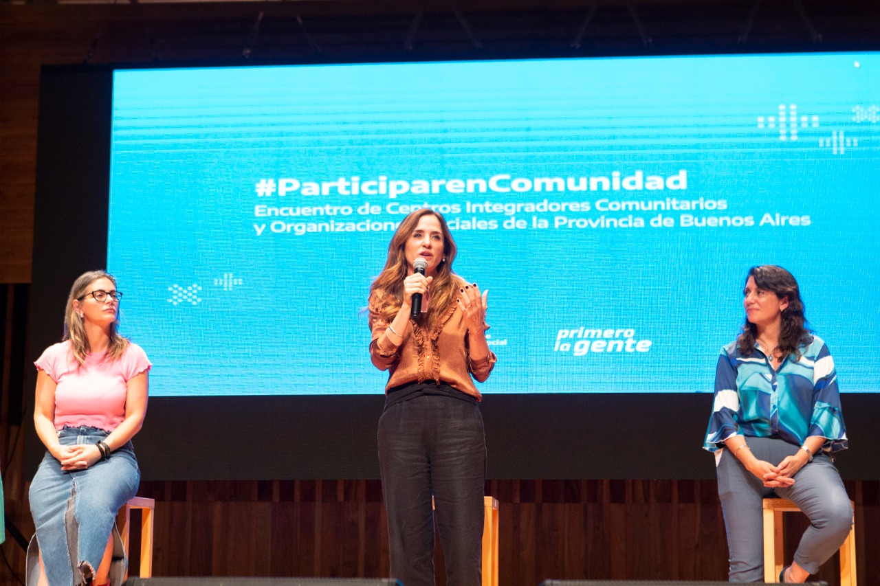 La ministra Victoria Tolosa Paz está en el escenario del auditorio exponiendo el programa Participar en Comunidad junto a Micaela Ferraro y Laura Berardo.