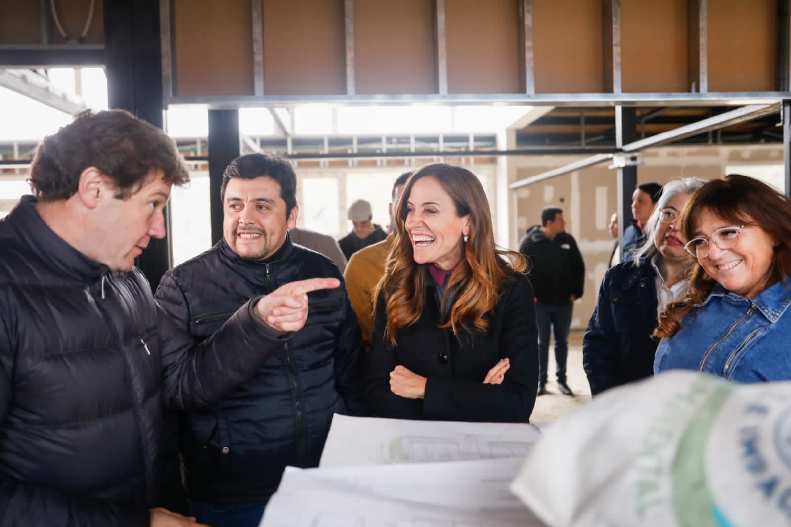 Victoria Tolosa Paz y Gustavo Melella participando en una conversación alrededor de los planos de construcción.