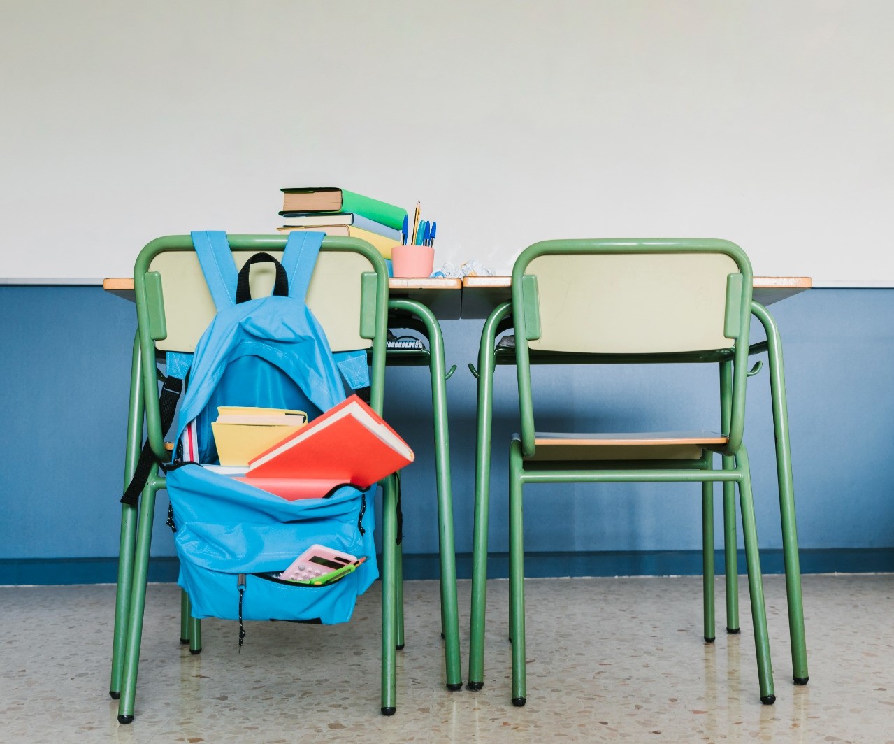 Fotografía de mesas  y sillas de un aula de escuela. 